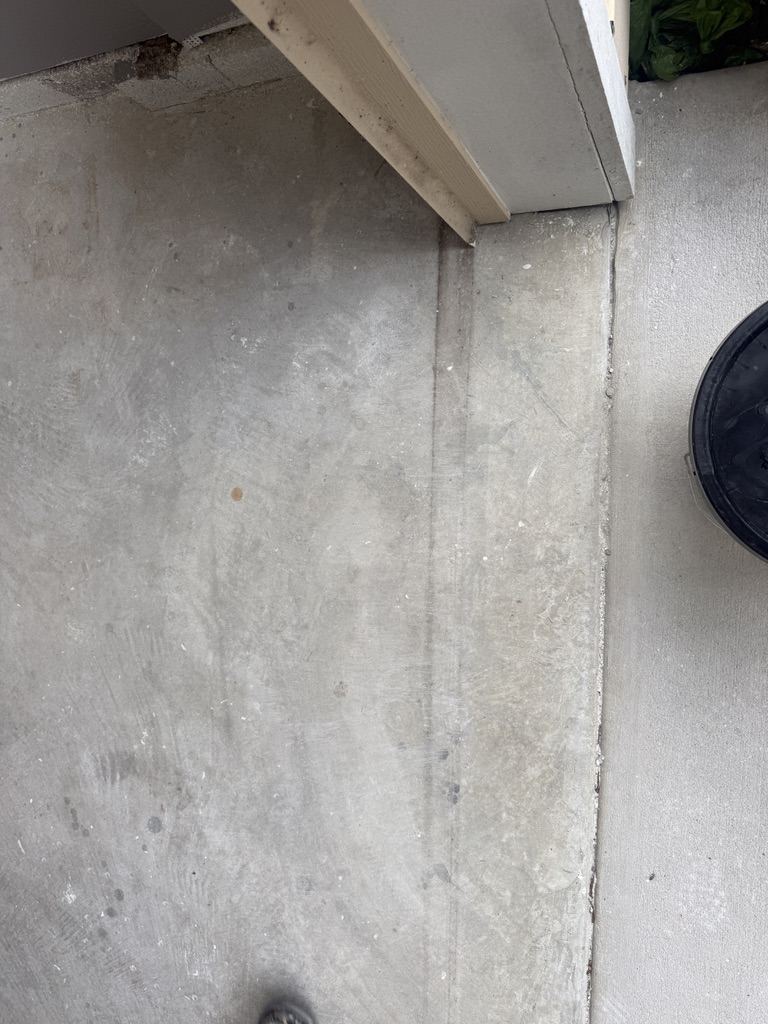 Bare concrete at a garage threshold before coating