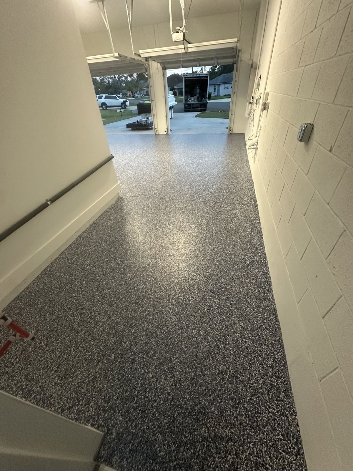 Gray flake garage floor coating at the doorway threshold