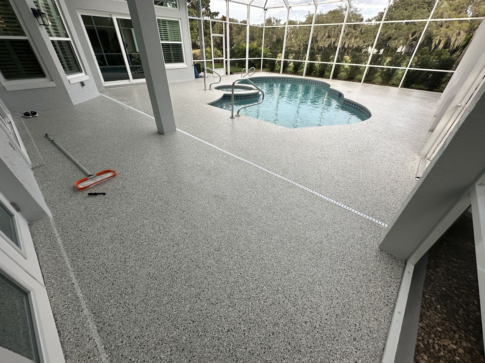 Gray flake pool deck coating on a screened lanai
