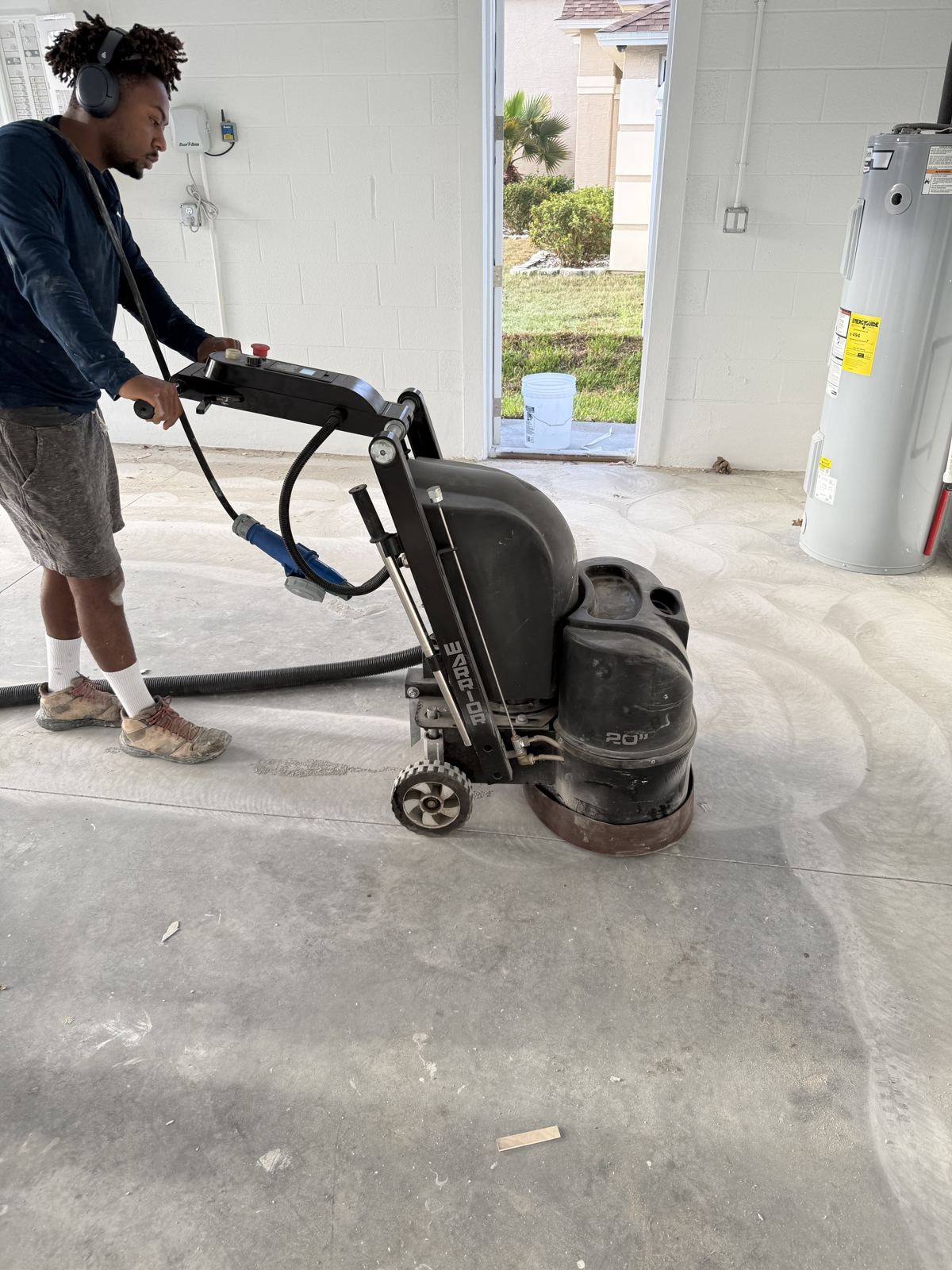 Diamond grinding a garage slab with dust extraction before coating